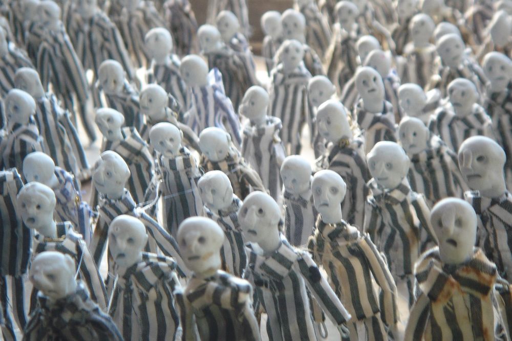 Close-up van tientallen poppetjes in gestreepte kleding, dicht op elkaar.