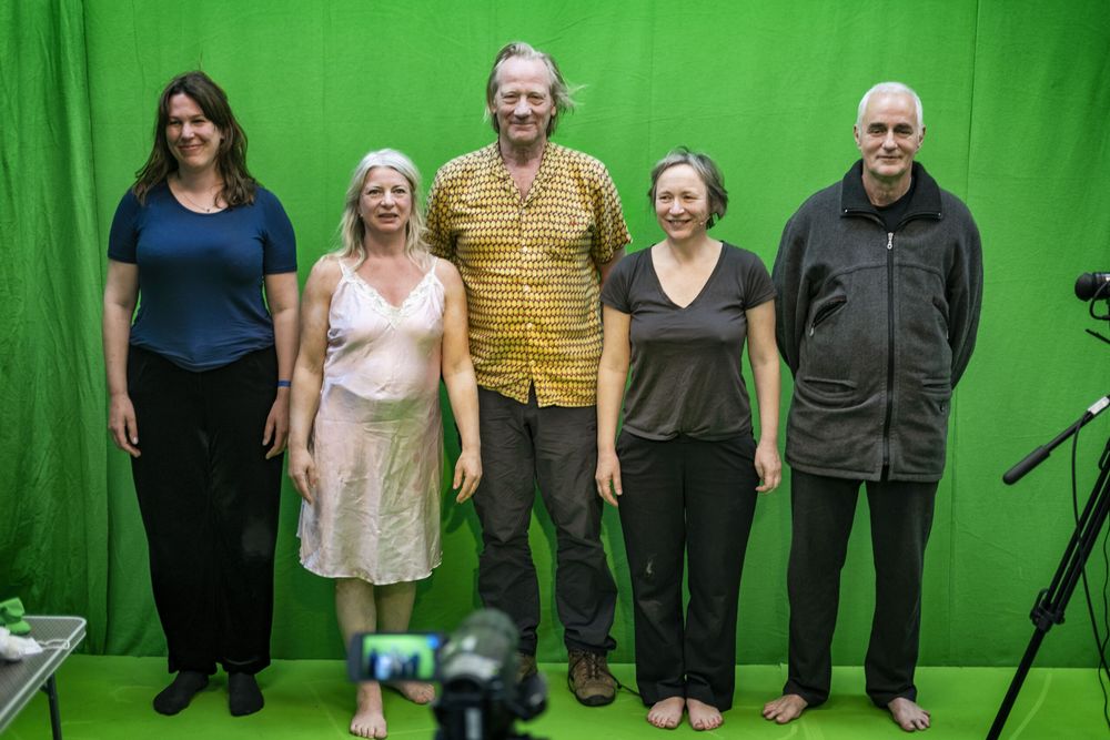 Groepsportret van vijf spelers naast elkaar voor het groene doek in de studio.